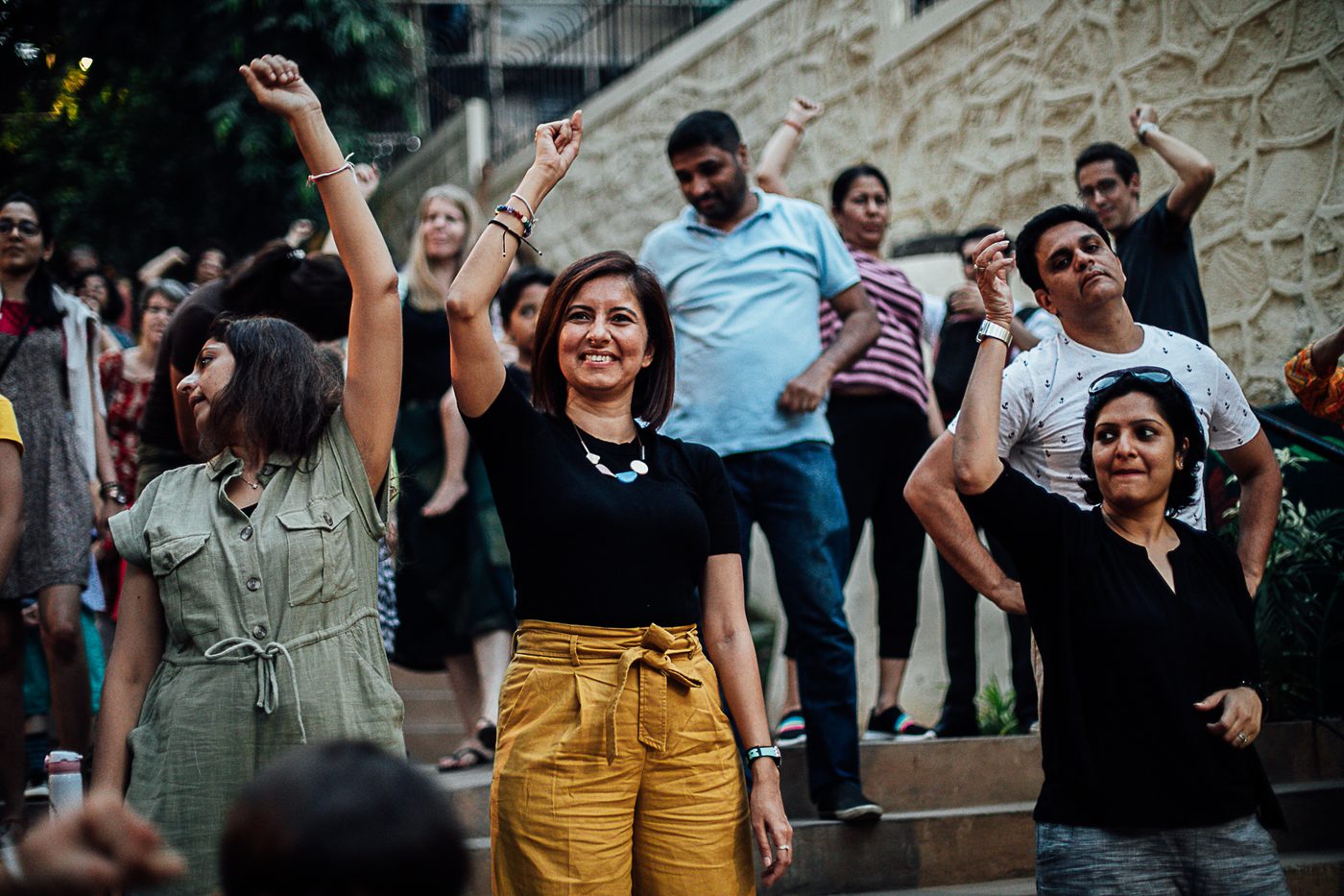 Women dancing with their arms raised on The Steps, smiling, with neighbours around them