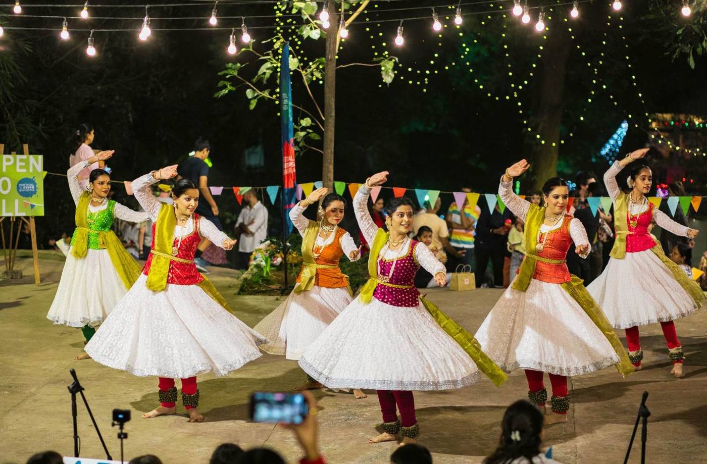 Kathak dancers performing under string lights